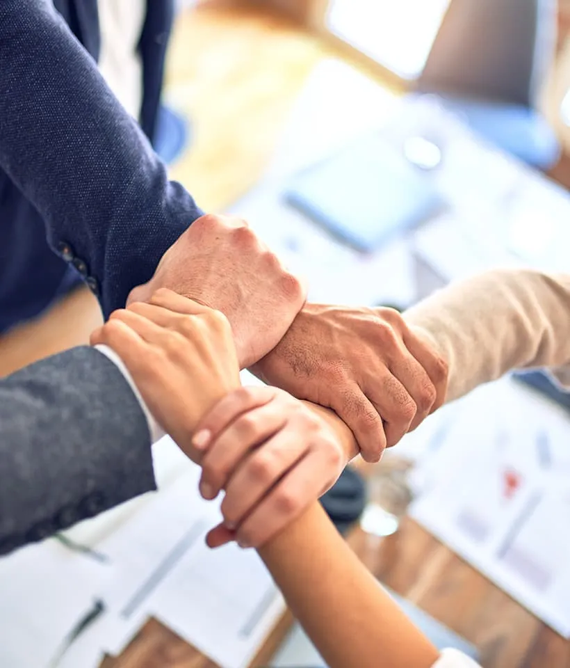 Vier Hände, die sich stützen